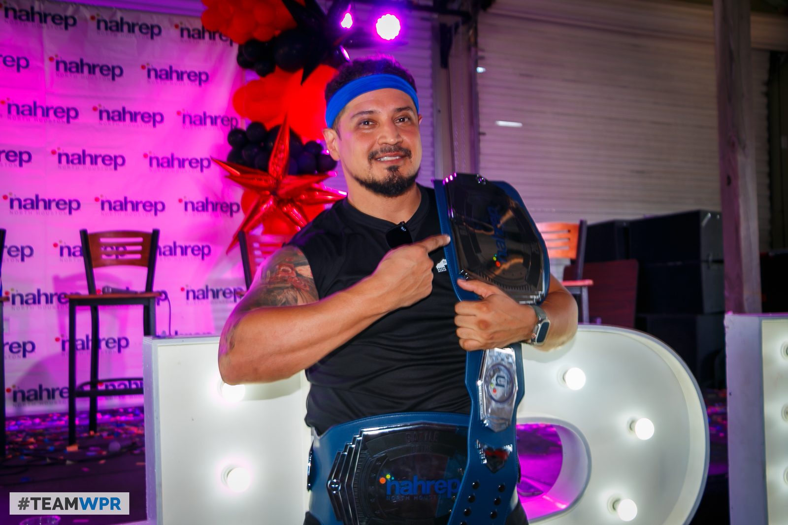 Alan R. Hernandez holding the Houston Battle of the Brokers championship belt